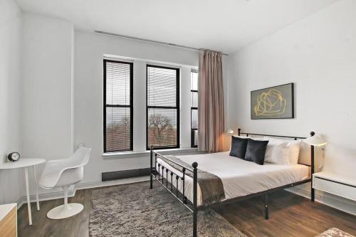 - une chambre avec un lit, un bureau et 2 fenêtres dans l'établissement Serene Studio Apartment in Hyde Park - Del Prado 706, à Chicago