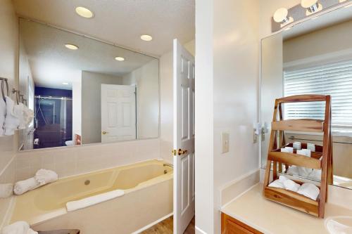 un bagno con vasca, lavandino e specchio di Rumbling Bald Resort Unit 2004 a Lake Lure