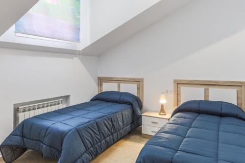 1 dormitorio con 2 camas y ventana en Villa Rural Las Lomas, en Jaén