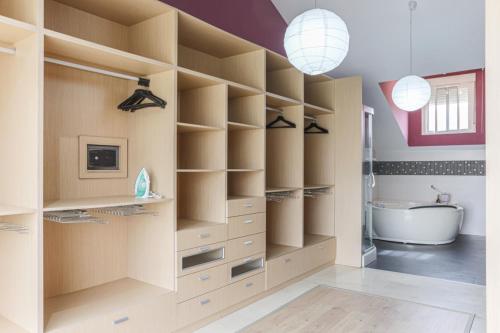 a bathroom with wooden shelves and a tub and a sink at Villa Rural Las Lomas in Jaén