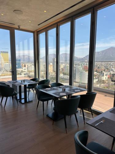 un ristorante con tavoli, sedie e ampie finestre di Sky Hotel Tirana a Tirana
