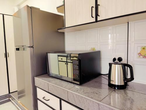 a microwave sitting on a counter in a kitchen at Fibonacci Beachfront Apartment in Flic-en-Flac