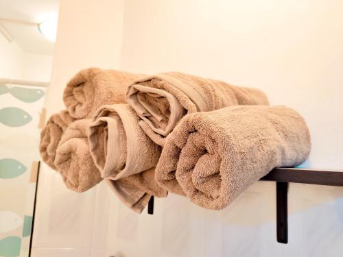 a pile of towels on a towel rack in a bathroom at Fibonacci Beachfront Apartment in Flic-en-Flac