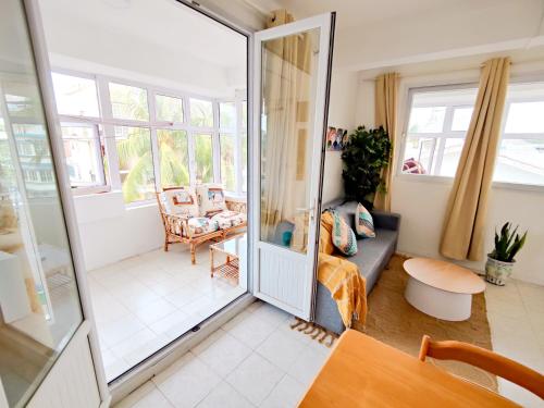 a living room with a door open to a living room at Fibonacci Beachfront Apartment in Flic-en-Flac