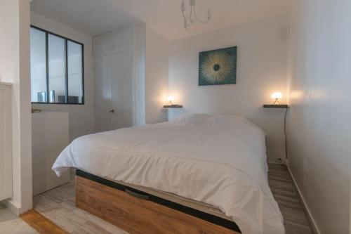 - une chambre avec un grand lit blanc et deux lampes dans l'établissement 2PERS terrasse vue mer piscine, à Menton