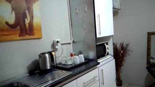 a kitchen with a sink and a microwave at Vee’s Guest House in East London