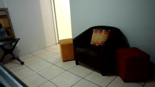 a black chair with a pillow in a room at Vee’s Guest House in East London