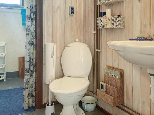 La salle de bains est pourvue de toilettes blanches et d'un lavabo. dans l'établissement Holiday home FIGEHOLM, à Figeholm
