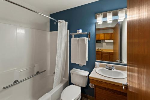 y baño con aseo blanco y lavamanos. en WoodSpring Suites El Paso, en El Paso