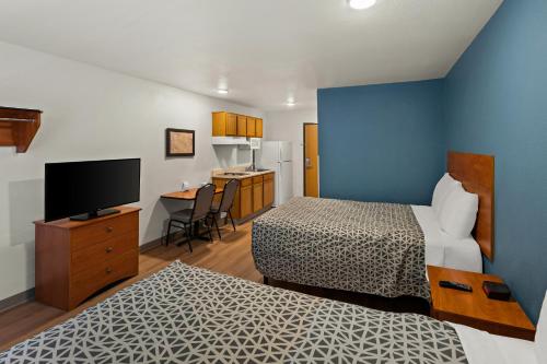 a hotel room with two beds and a television at WoodSpring Suites El Paso in El Paso