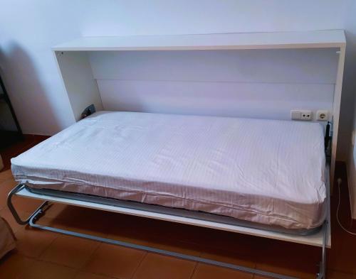 a bed in a small room with white sheets at Estudio Regency Alcaidesa in La Alcaidesa