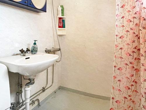 a bathroom with a sink and a shower curtain at Idyllic Getaway with Private Beach in Abbetorp
