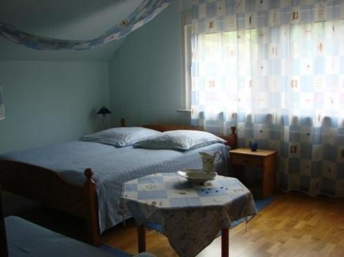 - une chambre avec un lit, une table et une fenêtre dans l'établissement Appartement in Schelingen mit Garten und Grill, à Schelingen
