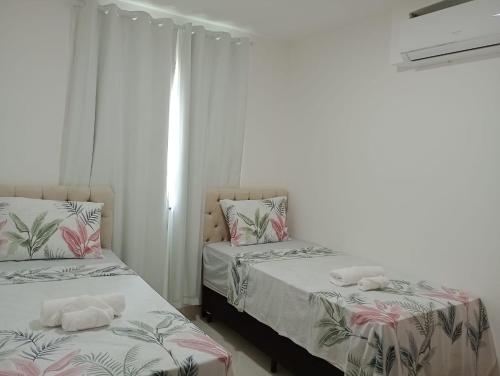 ein Schlafzimmer mit 2 Betten und Handtüchern darauf in der Unterkunft La Palma 204 - Apartamento na Praia dos Milionários - Ilhéus/BA in Ilhéus