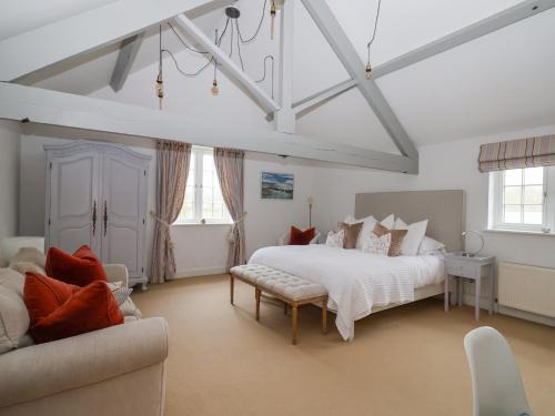 a bedroom with a large white bed and a couch at Apple Mill in Venn Ottery