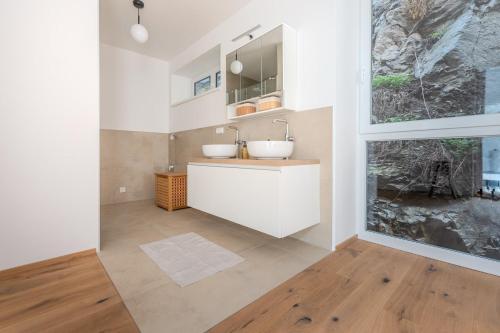 uma casa de banho com 2 lavatórios e uma grande janela em Krems Deluxe Apartments - Newly built em Krems an der Donau