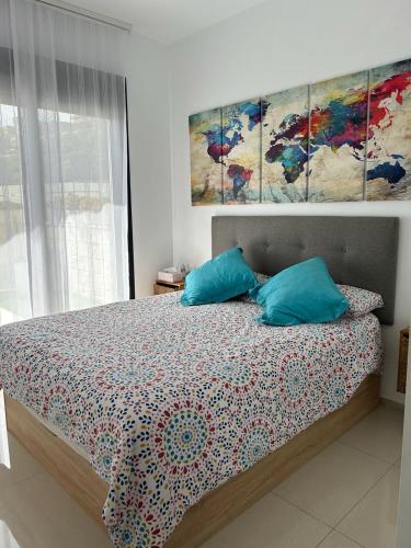 a bedroom with a bed with three paintings on the wall at Apartamento Postman in Arenales del Sol