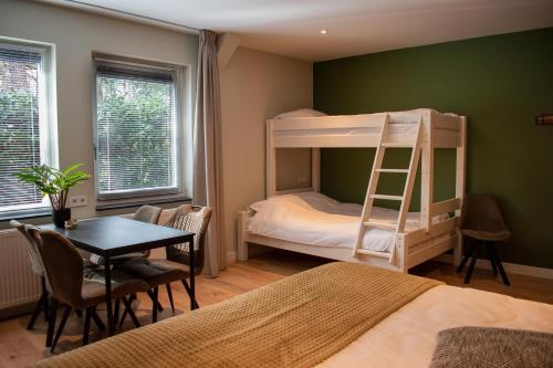 a bedroom with a bunk bed and a table and chairs at Hotel B&B Buiten Loon in Loon op Zand