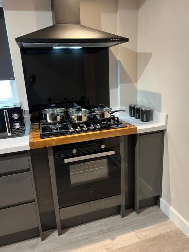 a kitchen with a stove with pots and pans at Wolf Inn Serviced Accommodation in Lowestoft