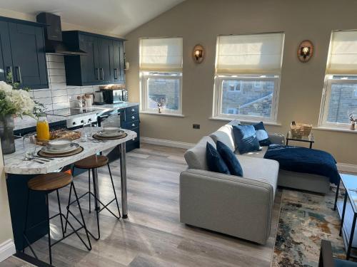 a kitchen and a living room with a couch and a table at Apartment in North Yorkshire (Crosshills) in Kildwick