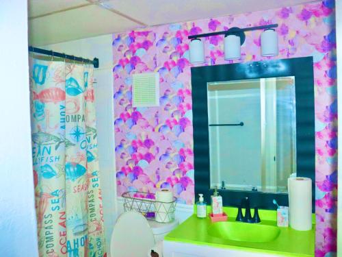 uma casa de banho com um lavatório verde e um espelho em Think Pink em Fort Worth