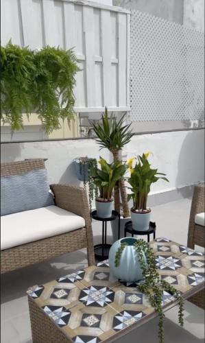 a patio with a table with potted plants on it at Palacete de La Alameda - Adults Only- in Cádiz