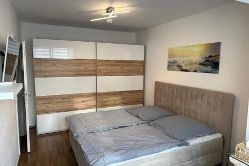 sypialnia z łóżkiem z drewnianym zagłówkiem w obiekcie Private Apartment w Hanowerze