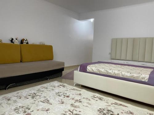 a bedroom with two beds and a couch and a rug at Guesthouse & Hospitality in Berat