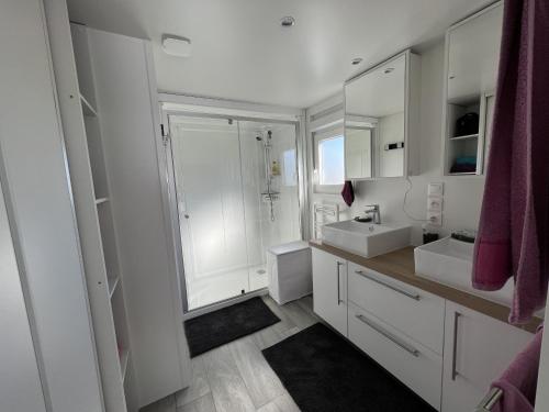 un bagno bianco con 2 lavandini e una doccia di Cottage haut de gamme 6 personnes avec spa & wifi a Sainte-Foy