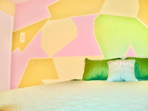 a bedroom with a colorful wall with a bed at Think Pink in Fort Worth