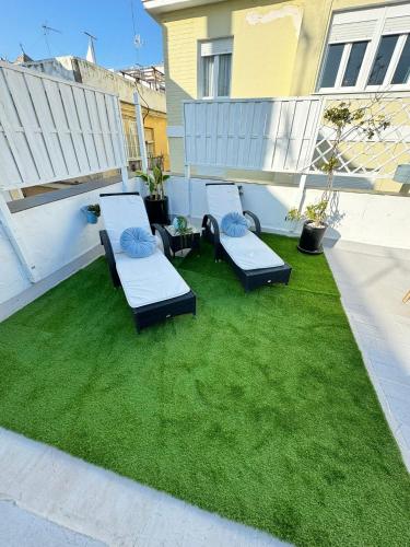 a patio with two chaise lounges on the grass at Palacete de La Alameda - Adults Only- in Cádiz