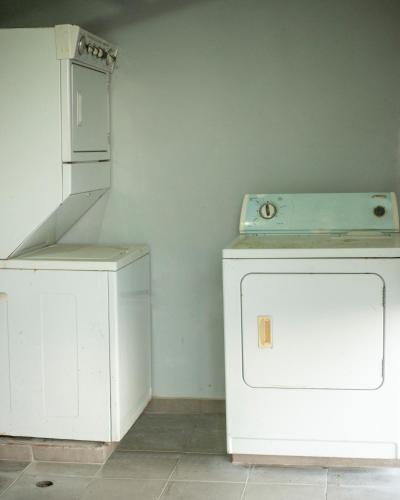 a washing machine and a washer and dryer in a room at Dpravia Hotel SRL in Baní