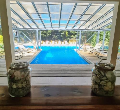 dos tarros de albañil sentados en una mesa frente a una piscina en Altos Los Pioneros & Spa en Villa La Angostura