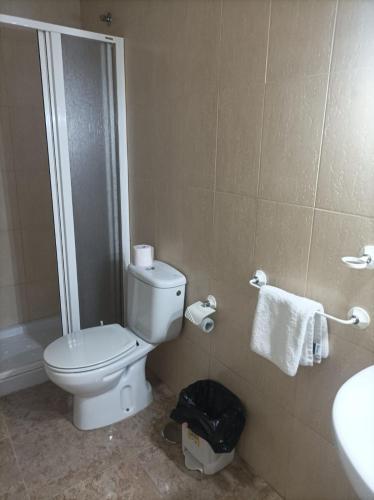 uma casa de banho com um WC branco e um lavatório. em PENSIÓN CARLOS III em Tomelloso