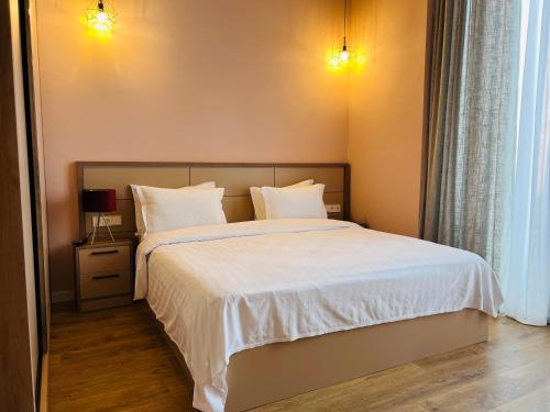 KachretʼiにあるVilla Ambassadori Kachreti Golf Resortのベッドルーム1室(白いシーツと枕のベッド1台付)