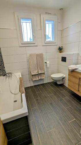 une salle de bain avec une baignoire, des toilettes et un lavabo dans l'établissement Jolie villa avec piscine à 15mn des plages, à Mauguio