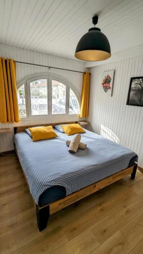 une chambre avec un grand lit avec des oreillers jaunes dans l'établissement Jolie villa avec piscine à 15mn des plages, à Mauguio