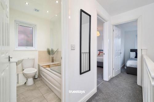 a bathroom with a toilet and a sink and a tub at Ashworth House by Truestays - NEW 3 Bedroom House in Failsworth, Manchester in Manchester