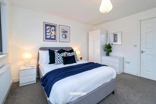 1 dormitorio con 1 cama con 2 mesitas de noche y 2 lámparas en Ashworth House by Truestays - NEW 3 Bedroom House in Failsworth, Manchester, en Mánchester