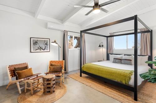 1 dormitorio con cama con dosel y silla en 2 Min To Dt, Fully Fenced, Hot Tub, Plunge Pool, en Joshua Tree