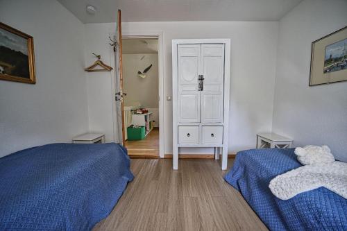 a bedroom with two beds and a door to a closet at Haus-unter-Reet in Nebel