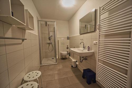 a bathroom with a sink and a toilet and a shower at Wohnung-Froemming in Wittdün