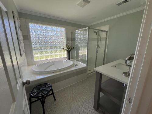 bagno con vasca, lavandino e finestra di Serene 3BR Pet-Friendly Getaway Near Cartersville a Cartersville