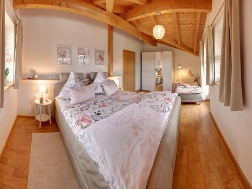 een groot bed in een kamer met houten plafonds bij Ferienhaus Naturzauber - Chiemgau Karte in Inzell