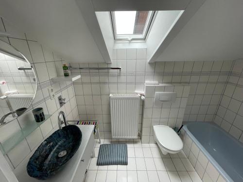 a bathroom with a sink and a tub and a toilet at Ferienwohnung am Moosbach in Anger