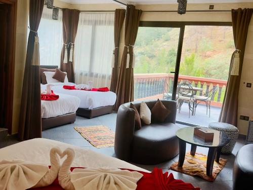 a hotel room with two beds and a balcony at Aurocher Ourika Oukaimeden in Oukkainrdem