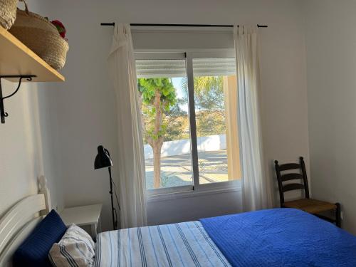 Un dormitorio con una cama azul y una ventana en Casa Montana tranquilidad en la Costa Cálida, en Mazarrón