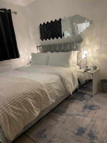 sypialnia z dużym białym łóżkiem i stolikiem w obiekcie En-suite bedroom in a family home near Gatwick airport and Horley station w mieście Hookwood