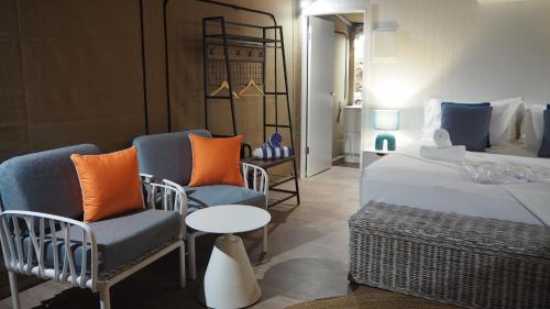 - une chambre avec un lit, deux chaises et une table dans l'établissement Deluxe King Safari Tent 2, à Nelly Bay