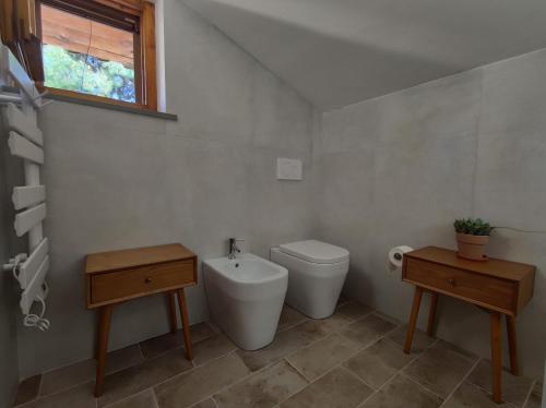 een badkamer met een toilet, een wastafel en een raam bij La Buganvilla in Sirolo
